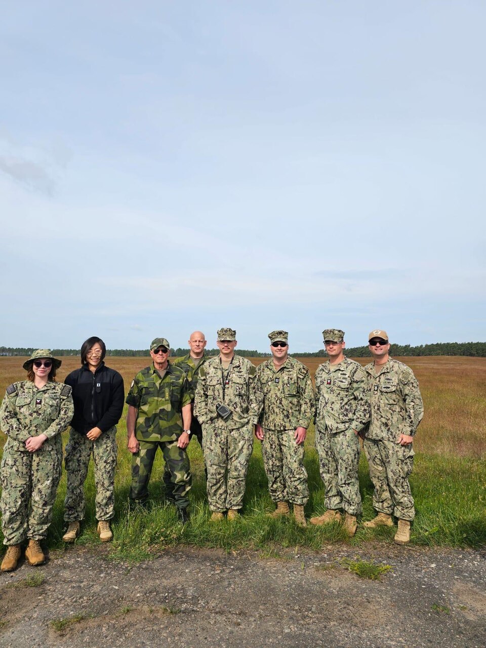 Lt. Xuan Li, Lt. Randy Buckley, Hospital Corpsman 1st Class Nicolas Garhartt, and Hosptial Corpsman 2nd Class Alexis Rivera, assigned to Navy Environmental Preventive Medicine Unit TWO (NEPMU-2), along with Sailors from 22 Naval Construction Regiment and Swedish military personnel pose for a group photo while conducting a expeditionary medical facility survey during BALTOPS25 in Rinkaby, Sweden, June 19, 2025. BALTOPS 25 is the premier maritime-focused annual military exercise in the Baltic region and provides a unique opportunity to strengthen warfighting readiness and combat credibility critical to deterrence and preserving safety and security in the Baltic Sea.