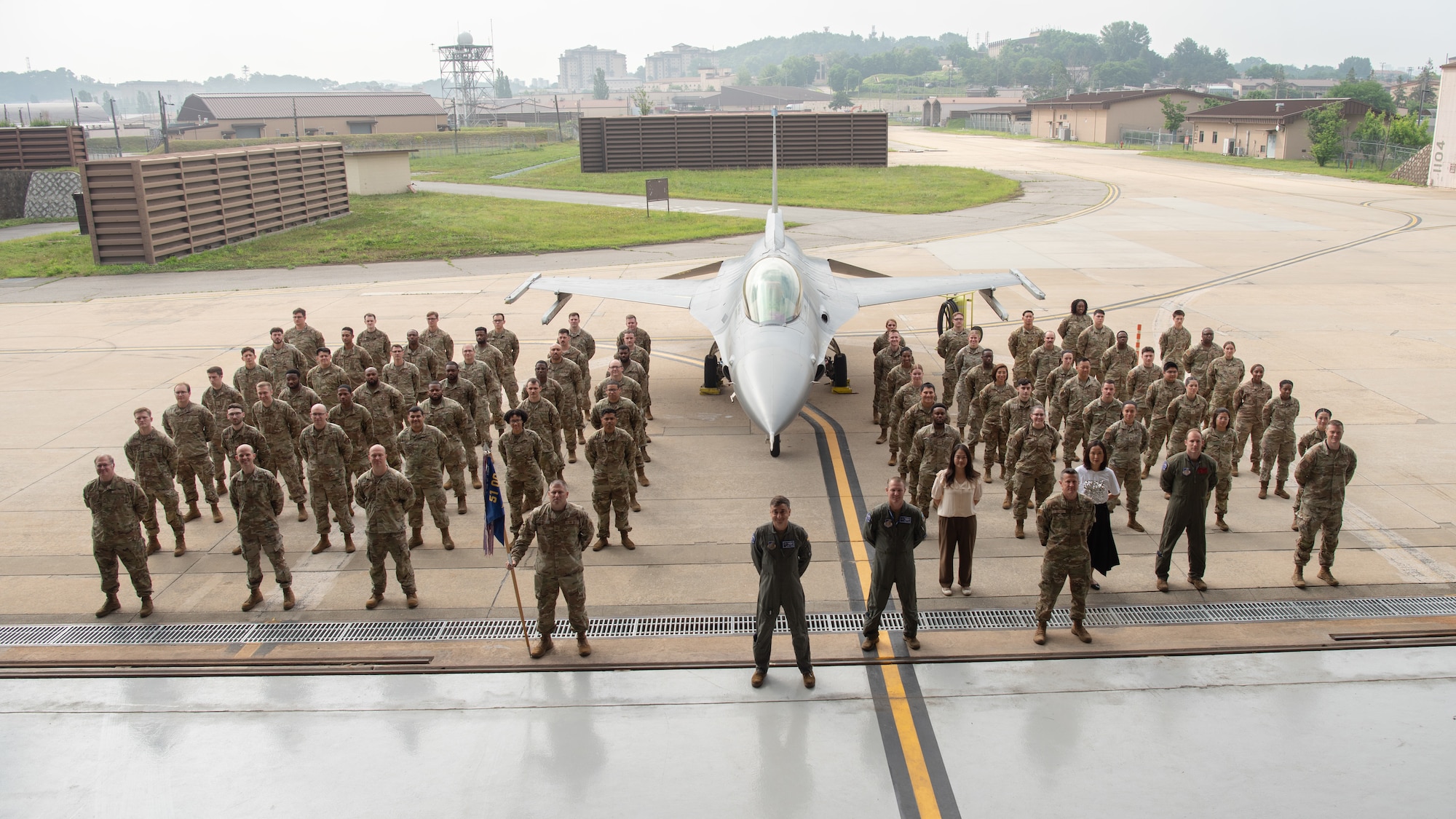 The 51st Operation Support Squadron poses for a squadron photo next to an F-16 Fighting Falcon during a Change of Command ceremony at Osan Air Base, Republic of Korea, June 18, 2025.
