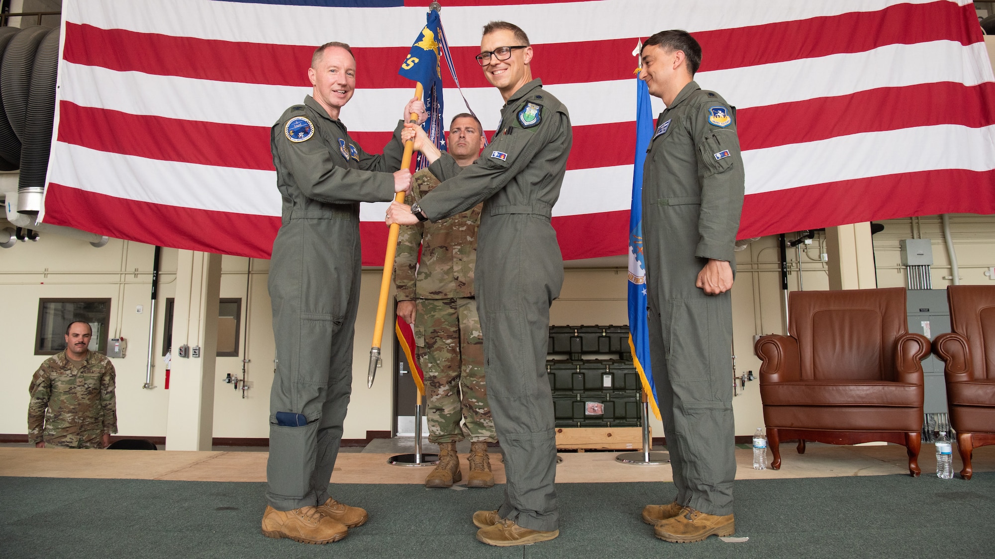 U.S. Air Force Lt. Col Joseph Morrin, outgoing 51st Operations Support Squadron commander, middle, relinquishes command of the 51st OSS to Col. Kurt Distelzweig, 51st Operations Group commander, left, during a Change of Command ceremony at Osan Air Base, Republic of Korea, June 18, 2025.