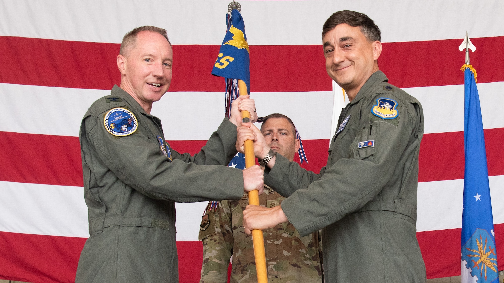 U.S. Air Force Lt. Col. Lance Tucker, incoming 51st Operations Support Squadron commander, right, accepts command of the 51st OSS from Col. Kurt Distelzweig, 51st Operations Group commander, left, during a Change of Command ceremony at Osan Air Base, Republic of Korea, June 18, 2025.