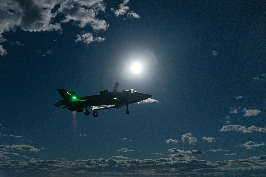 U.S. Marine Corps F-35B Lightning II aircraft assigned to Marine Fighter Attack Squadron (VMFA) 242, 31st Marine Expeditionary Unit, prepares to land during night flight operations aboard the amphibious assault ship USS America (LHA 6), in the Coral Sea, June 12, 2025. Marine F-35Bs bring a 5th generation multi-discipline strike capability to support combined-joint all domain operations in key maritime terrain. The 31st MEU is operating aboard ships of the USS America Amphibious Ready Group in the 7th Fleet area of operations, the U.S. Navy’s largest forward-deployed numbered fleet, and routinely interacts and operates with allies and partners in preserving a free and open Indo-Pacific region. (U.S. Marine Corps photo by Lance Cpl. Victor Gurrola)