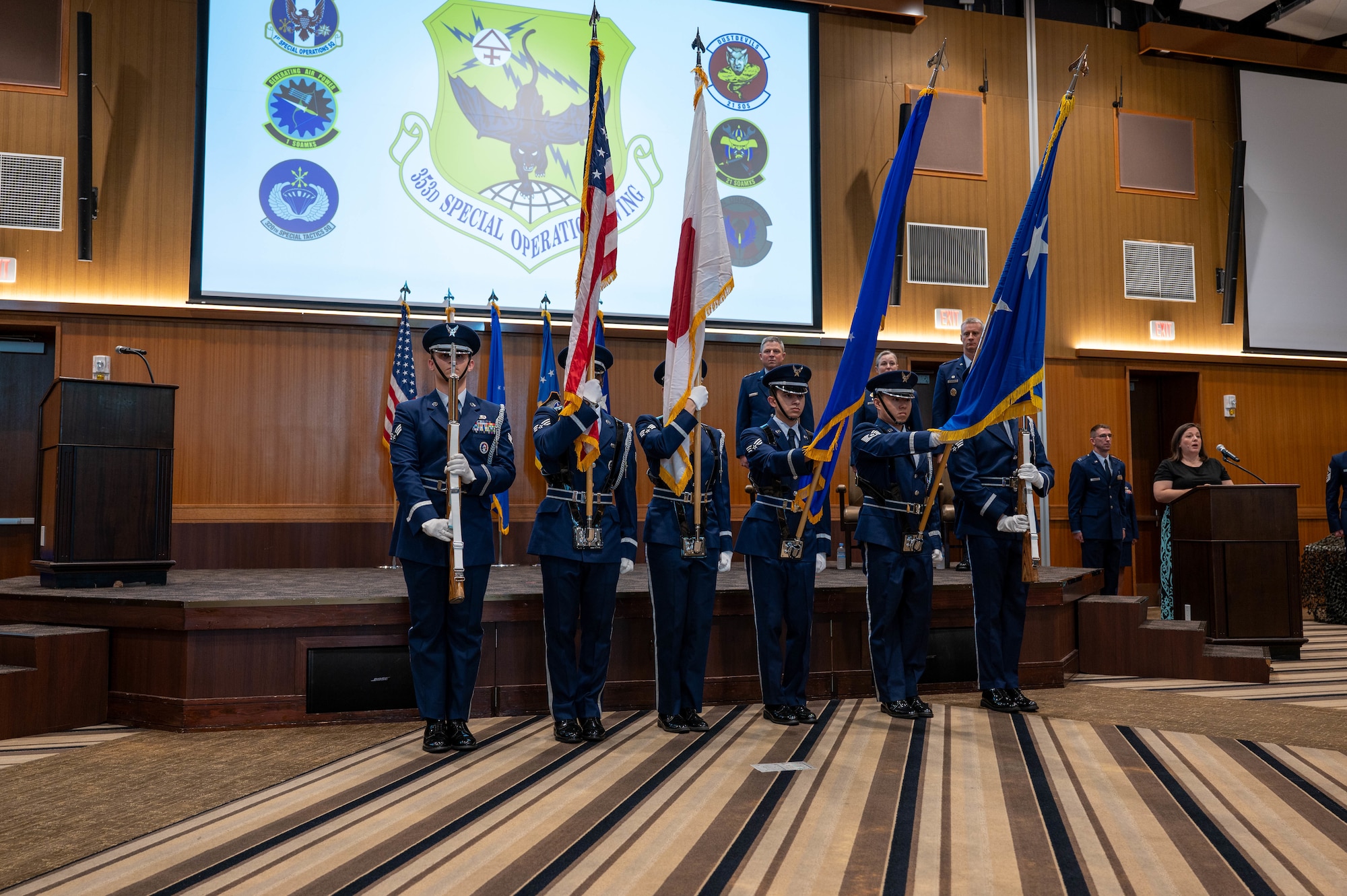 Service members raise flags in ceremony.