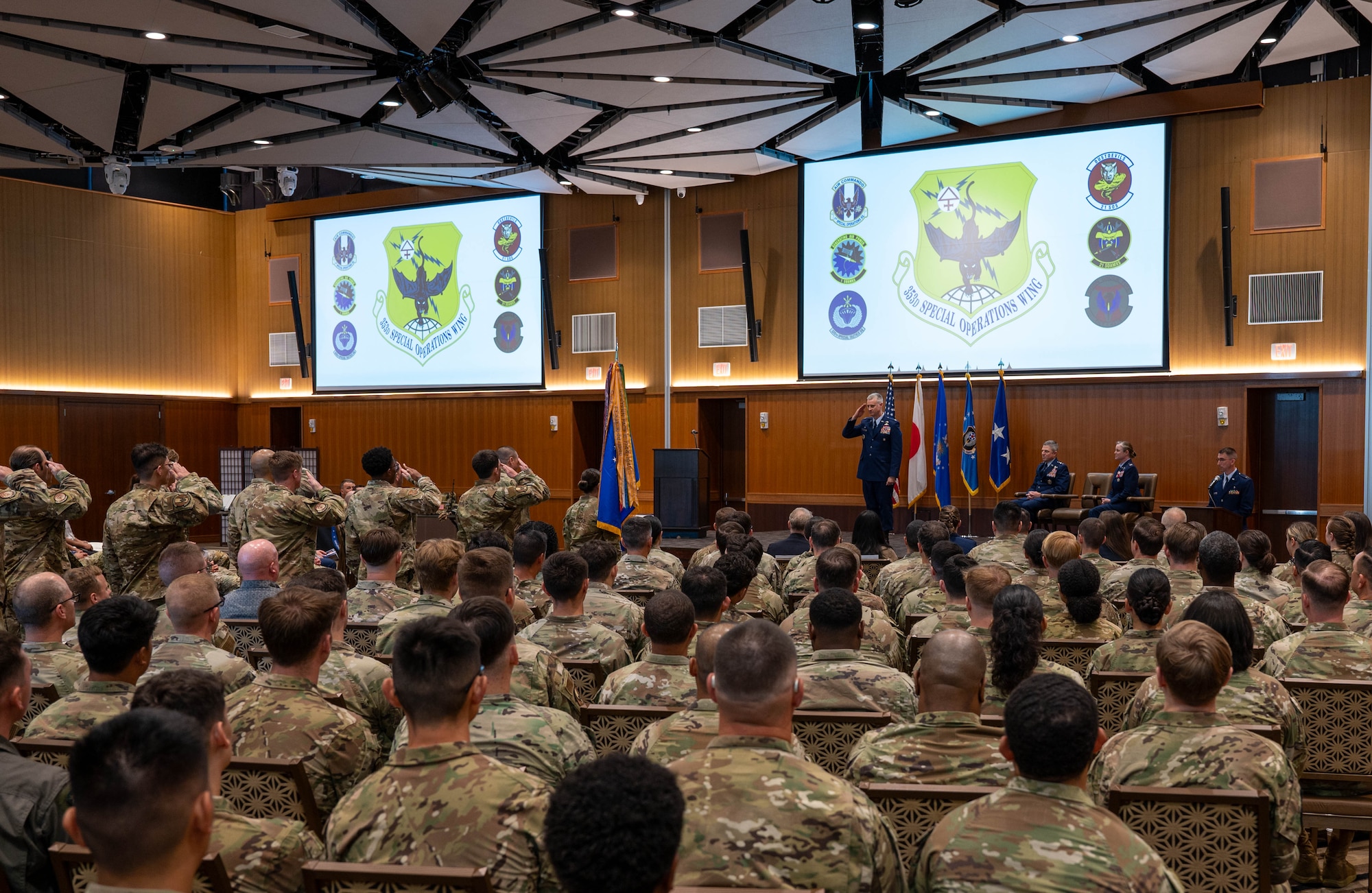 Group of service members salute commander.