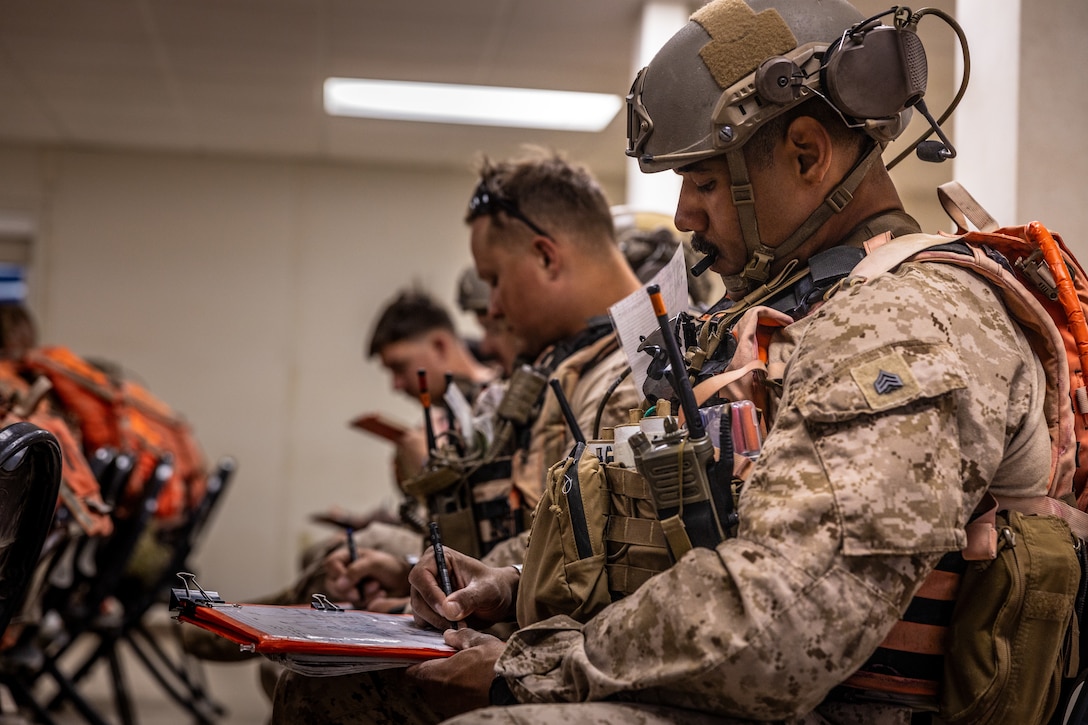 U.S. Marines with the Tactical Training Exercise Control Group, Marine Air-Ground Task Force Training Command take notes during a safety brief at Integrated Training Exercise 3-25 (ITX 3-25) at Marine Corps Air Ground Combat Center, Twentynine Palms, California, June 15th, 2025. ITX enhances Marines’ lethality by empowering leaders at every level to adapt, communicate, and execute dynamic movements in hostile environments. (U.S. Marine Corps photo by Lance Cpl. Edward Spears)