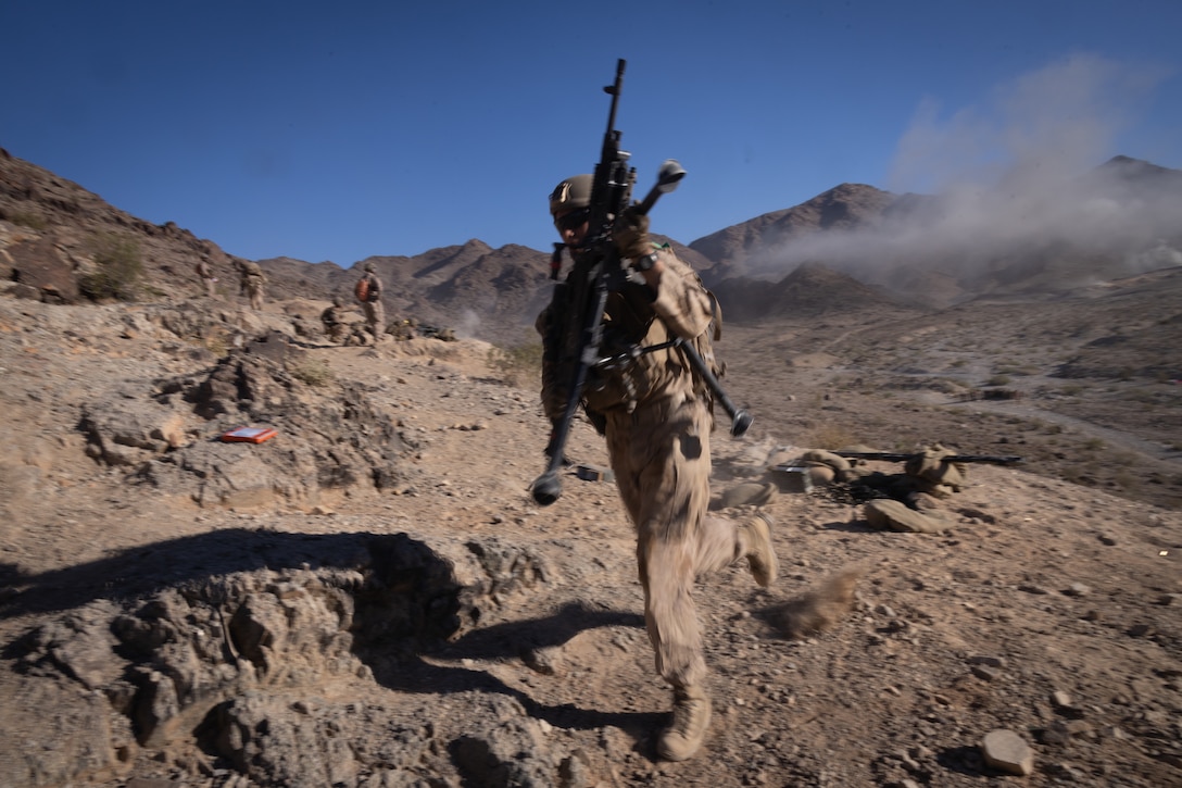A U.S. Marine with 2nd Battalion, 23rd Marine Regiment, 4th Marine Division runs with an M240 machine gun on Machine Gun Hill at Range 400 during Integrated Training Exercise 3-25 (ITX 3-25) at Marine Corps Air Ground Combat Center, Twentynine Palms, California, June 15th, 2025. ITX is a critical Marine Air-Ground Task Force exercise for the Marine Forces Reserve’s training cycle, confirming unit readiness through live-fire and combined arms integration. (U.S. Marine Corps photo by Lance Cpl. Edward Spears)