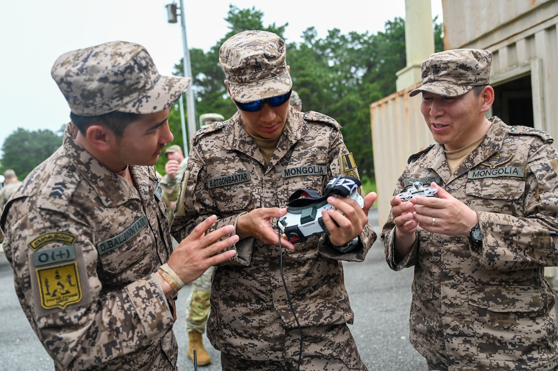 Mongolian soldiers, examining drone U.S. drone equipment at Joint Base Cape Cod, Massachusetts, June 19, 2025 during exercise Regional Cooperation 25. Regional Cooperation 25 is an annual, multinational U.S. Central Command sponsored command-post and field training exercise conducted by National Guard units in partnership with Central and South Asia nations. (U.S. Air Force photo by Staff Sgt. Colten Tessness)