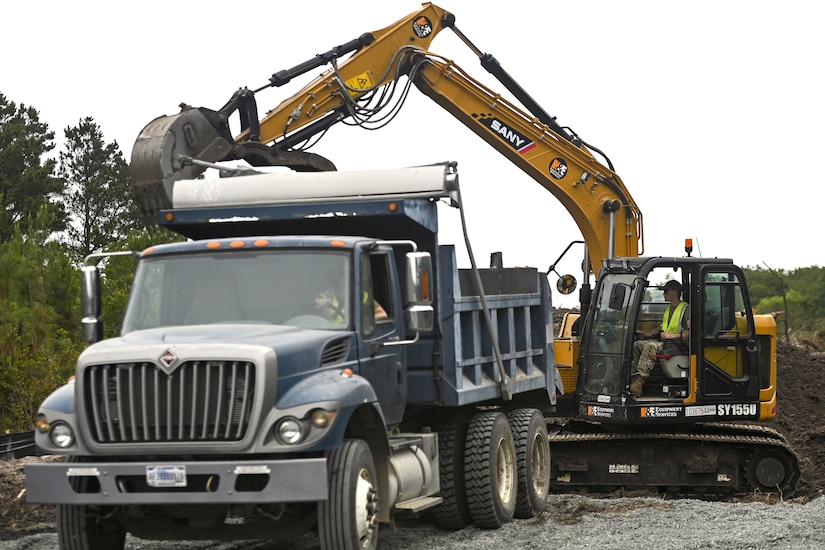 Pennsylvania Air National Guardsman, Senior Airman John Trimbath, assigned to the 171st Civil Engineer Squadron, loads debris into a dump truck while operating an excavator during a deployment for training, Assateague Island, Virginia, June 17, 2025. The 171st engineers are the 5th rotation of 8 during the deployment for training on the island. The DFT has provided engineers with unique training consistent with installing a runway while creating a new road for the Fish and Wildlife Service. (U.S. Air National Guard photo by Senior Master Sgt. Bryan Hoover)