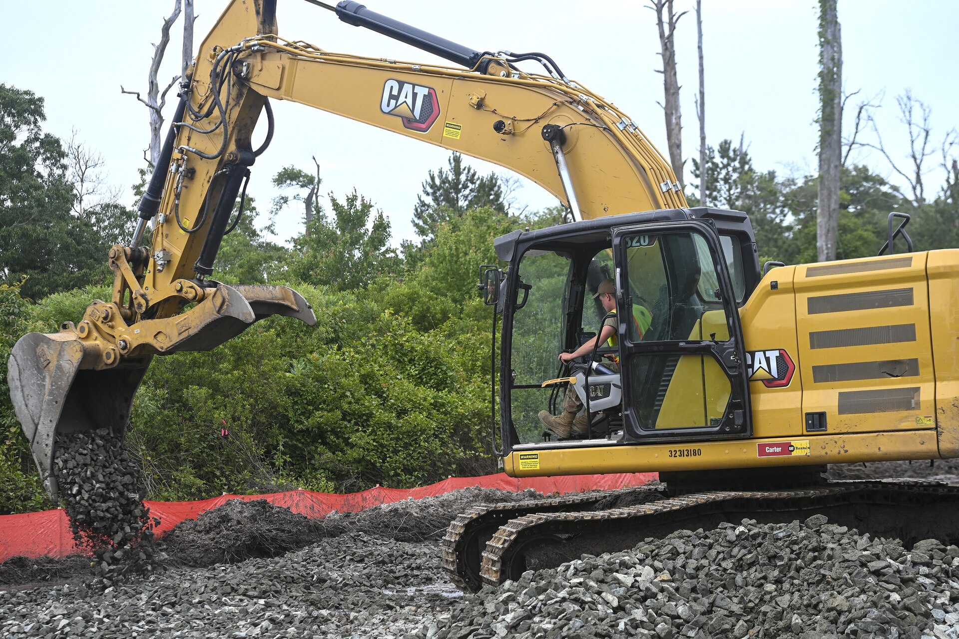 Pennsylvania Air National Guardsman, Senior Airman Asa Henderson assigned to the 171st Civil Engineer Squadron, operates an excavator to move riprap during a deployment for training, Assateague Island, Virginia, June 17, 2025. The 171st engineers are the 5th rotation of 8 during the deployment for training on the island. The DFT has provided engineers with unique training consistent with installing a runway while creating a new road for the Fish and Wildlife Service. (U.S. Air National Guard photo by Senior Master Sgt. Bryan Hoover)