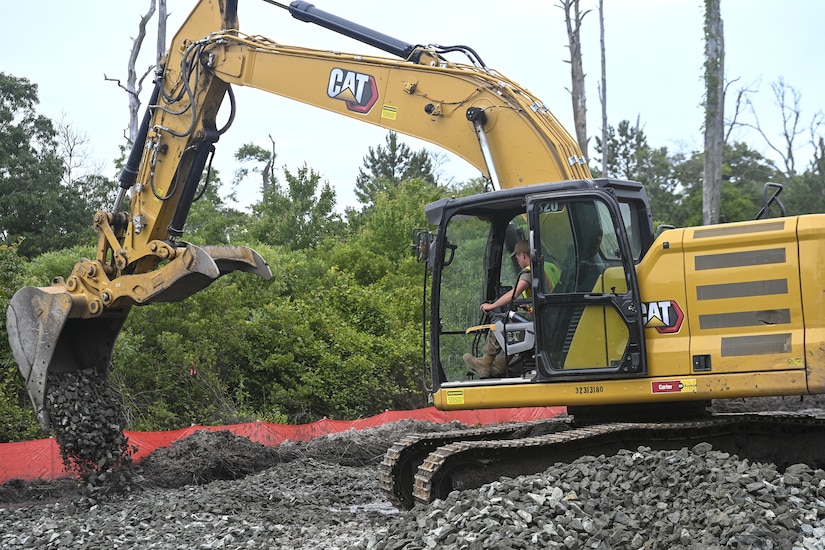 Pennsylvania Air National Guardsman, Senior Airman Asa Henderson assigned to the 171st Civil Engineer Squadron, operates an excavator to move riprap during a deployment for training, Assateague Island, Virginia, June 17, 2025. The 171st engineers are the 5th rotation of 8 during the deployment for training on the island. The DFT has provided engineers with unique training consistent with installing a runway while creating a new road for the Fish and Wildlife Service. (U.S. Air National Guard photo by Senior Master Sgt. Bryan Hoover)