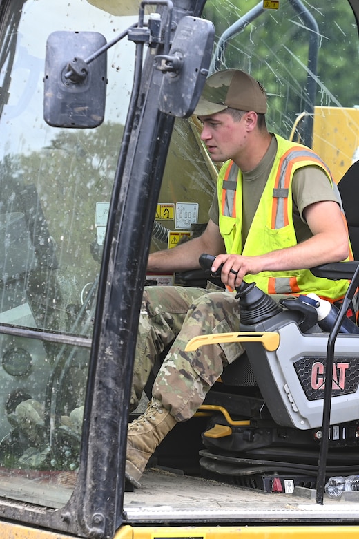 Pennsylvania Air National Guardsman, Senior Airman Asa Henderson assigned to the 171st Civil Engineer Squadron, operates an excavator to move riprap during a deployment for training, Assateague Island, Virginia, June 17, 2025. The 171st engineers are the 5th rotation of 8 during the deployment for training on the island. The DFT has provided engineers with unique training consistent with installing a runway while creating a new road for the Fish and Wildlife Service. (U.S. Air National Guard photo by Senior Master Sgt. Bryan Hoover)