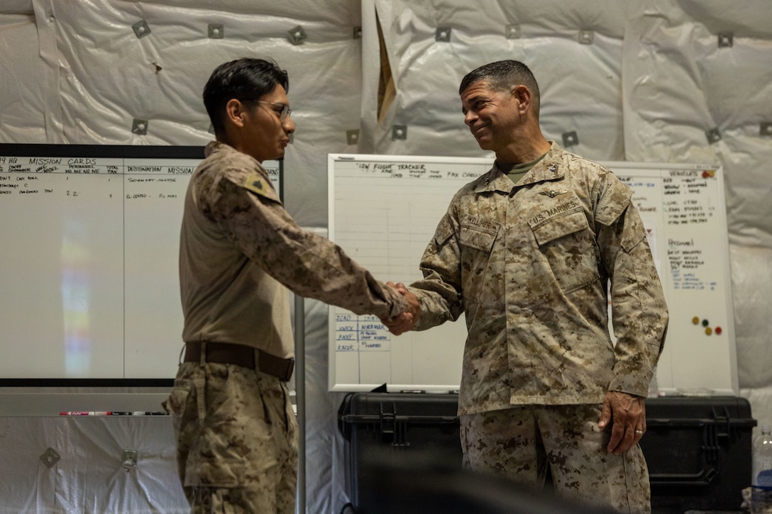 U.S. Marine Corps Cpl. Kyle Arnold of Marine Air Support Squadron 6, 4th Marine Aircraft Wing (left), and Maj. Gen. John Kelliher, commanding general of 4th Marine Aircraft Wing, Marine Forces Reserve, shake hands at Integrated Training Exercise 3-25, Marine Corps Air Ground Combat Center, Twentynine Palms, California, June 11, 2025. ITX is a critical Marine Air-Ground Task Force exercise for the Marine Forces Reserve’s training cycle, confirming unit readiness through live-fire and combined arms integration. (U.S. Marine Corps photo by Lance Cpl. Edward Spears)