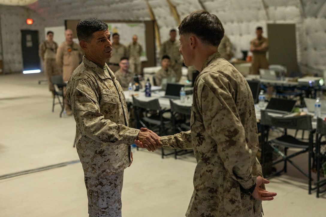 U.S. Marine Corps Sgt. Luis Sanchez Caceres of Marine Aircraft Group 49, 4th Marine Aircraft Wing (left), and Maj. Gen. John Kelliher, commanding general of 4th Marine Aircraft Wing, Marine Forces Reserve, discuss leadership development at Integrated Training Exercise 3-25, Marine Corps Air Ground Combat Center, Twentynine Palms, California, June 11, 2025. ITX is a critical Marine Air-Ground Task Force exercise for the Marine Forces Reserve’s training cycle, confirming unit readiness through live-fire and combined arms integration. (U.S. Marine Corps photo by Lance Cpl. Edward Spears)