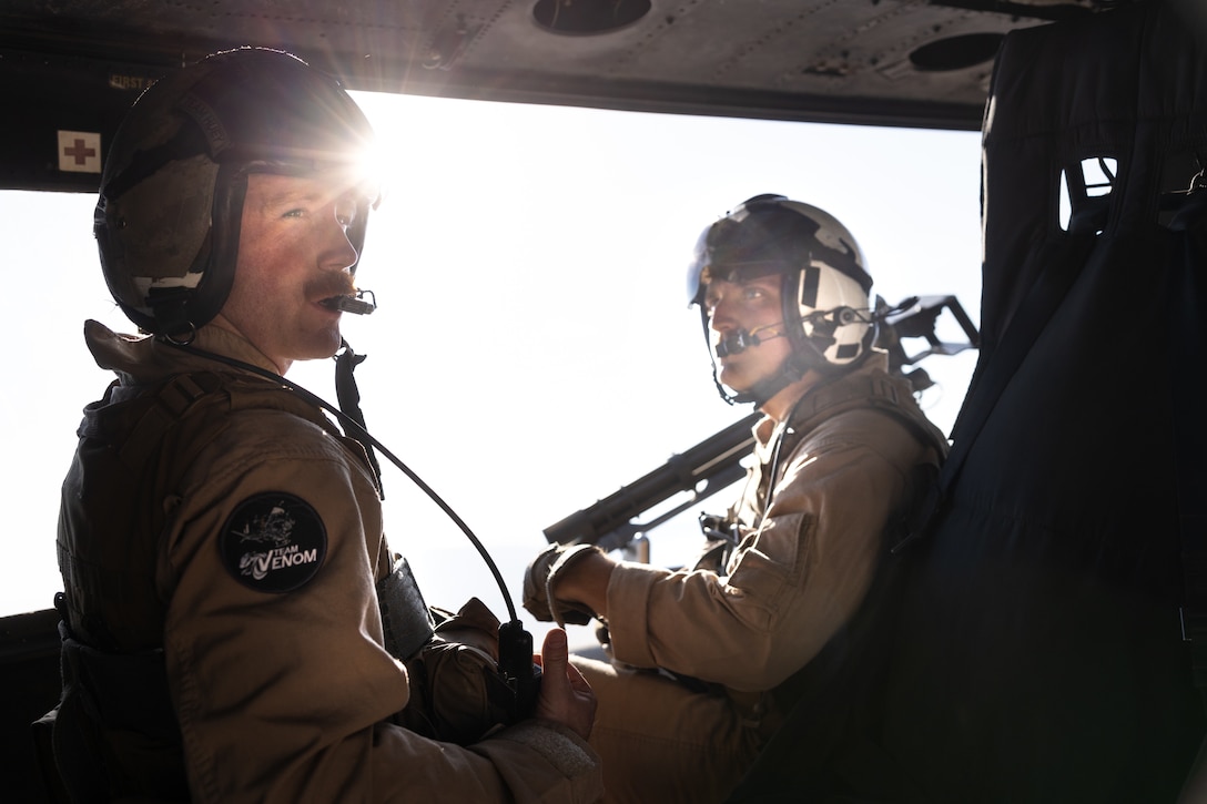 U.S. Marine Corps Gunnery Sgt. Daniel Fitzgerald, left, a weapons and tactics instructor with Marine Aircraft Group, and Cpl. Cody Gates, crew chief with Marine Light Attack Helicopter Squadron (HMLA) 773, 4th Marine Air Wing communicates exercise objectives during Integrated Training Exercise 3-25 (ITX 3-25) at Marine Corps Air Ground Combat Center, Twentynine Palms, California, June 11th, 2025. ITX enhances Marines’ lethality by empowering leaders at every level to adapt, communicate, and execute dynamic movements in hostile environments. (U.S. Marine Corps photo by Lance Cpl. Edward Spears)