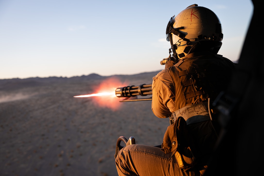 U.S. Marine Corps Cpl. Cody Gates, crew chief with Marine Light Attack Helicopter Squadron (HMLA) 773, 4th Marine Air Wing fire a machine gun at enemy combatants during Integrated Training Exercise 3-25 (ITX 3-25) at Marine Corps Air Ground Combat Center, Twentynine Palms, California, June 11th, 2025. ITX enhances Marines’ lethality by empowering leaders at every level to adapt, communicate, and execute dynamic movements in hostile environments. (U.S. Marine Corps photo by Lance Cpl. Edward Spears)
