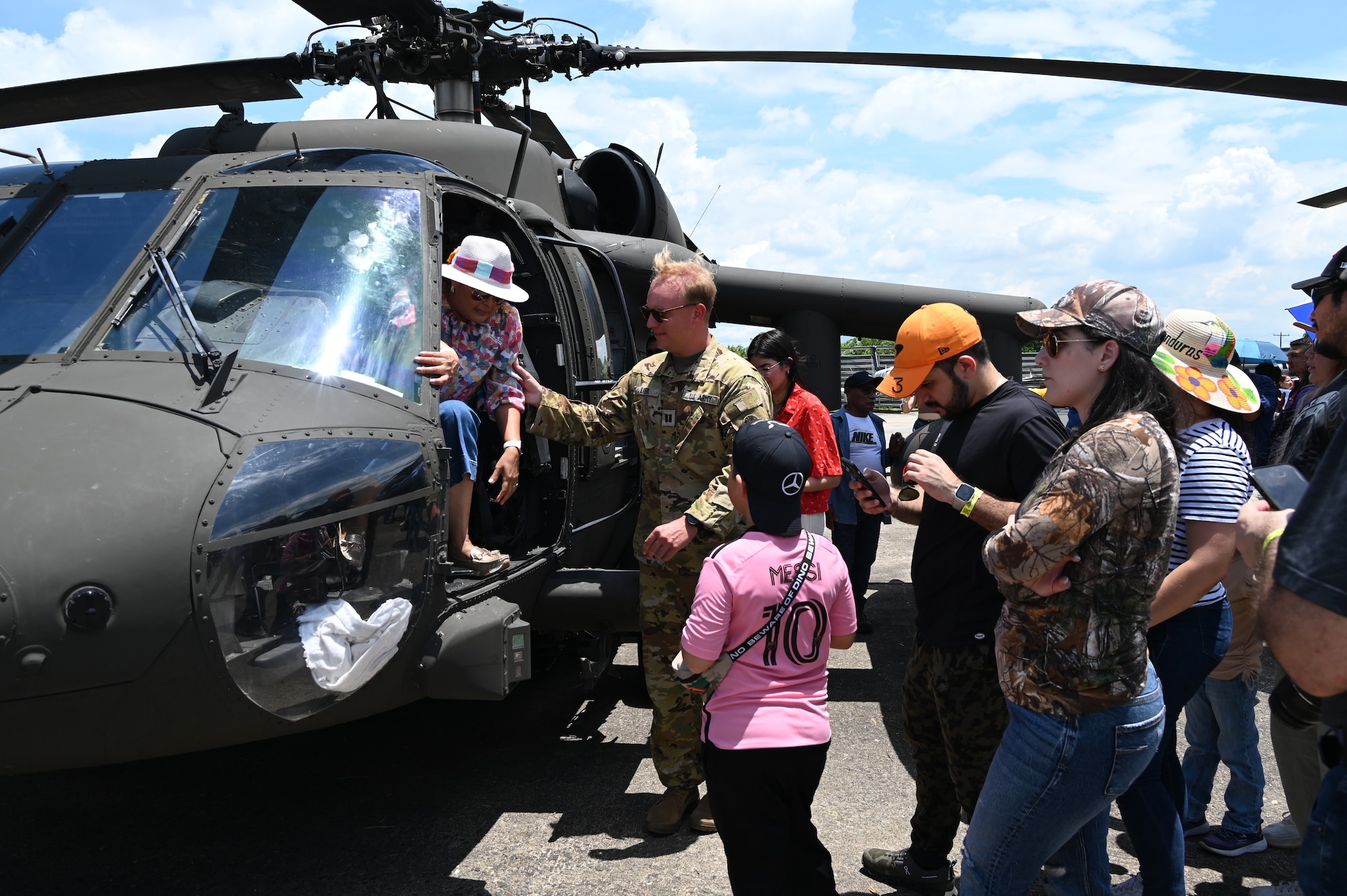 Capt. Max Liebl, UH-60 pilot and company commander with the 1-228th Aviation Regiment assists someone exiting the Black Hawk to ensure their safety during the Honduran Fuerza Aerea Air Show