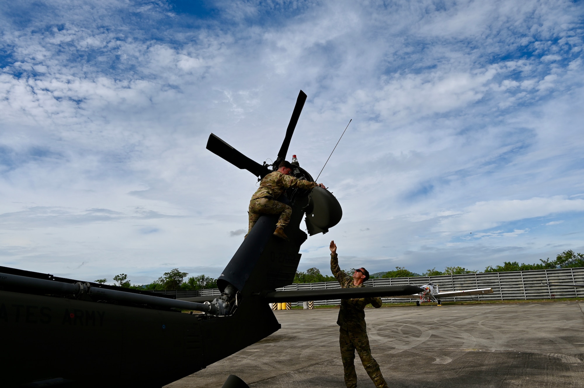 Staff Sgt. Austin Blackmer hands a protective covering of the UH-60 to Spc. Zach Stock during flight pre-checks.