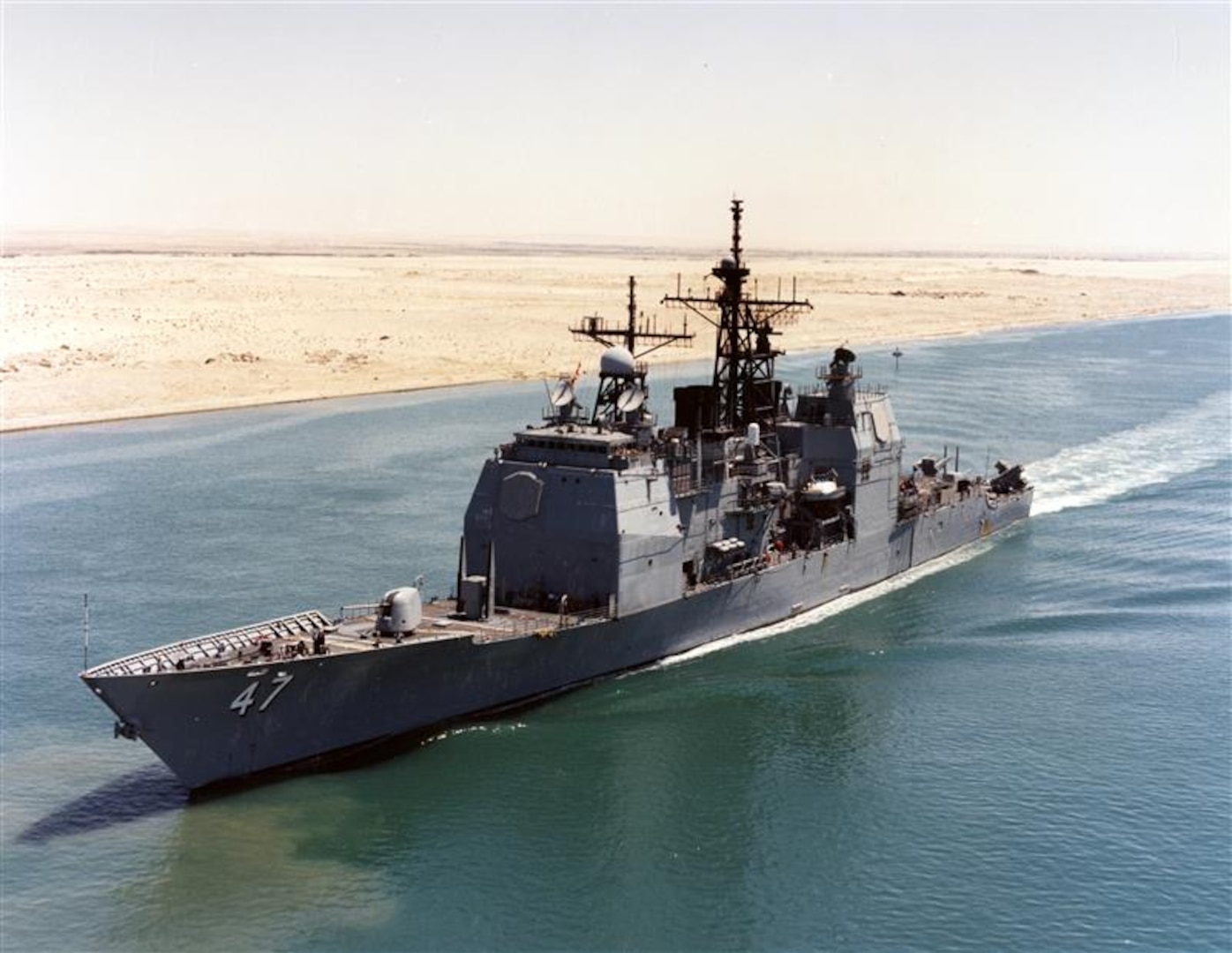 SUEZ CANAL — USS Ticonderoga (CG 47), the first in its class and the first U.S. Navy combat vessel to incorporate the Aegis Combat System, transiting the Suez Canal enroute to the Mediterranean Sea, following a deployment in support of Operation Desert Shield, Aug. 22, 1990. (PH3 Frank A. Marquart/Official U.S. Navy Photograph, from the collections of the Naval History and Heritage Command)