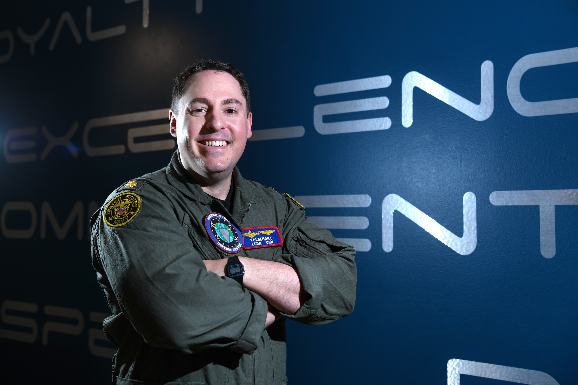 Man in flight suit folding his arms and smiling