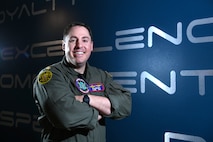 Man in flight suit folding his arms and smiling