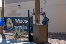 A service member speaks at a podium.