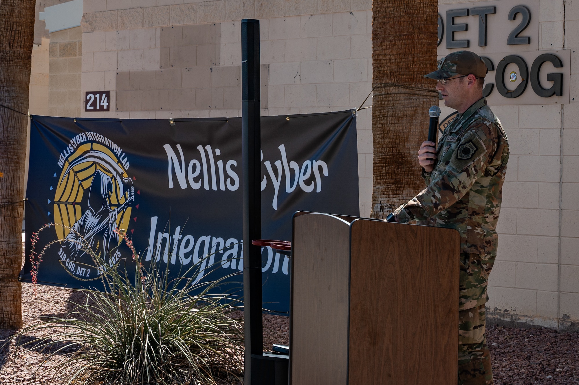 A man at a podium speaking in front of a building.