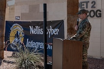 A man at a podium speaking in front of a building.