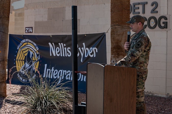A man at a podium speaking in front of a building.