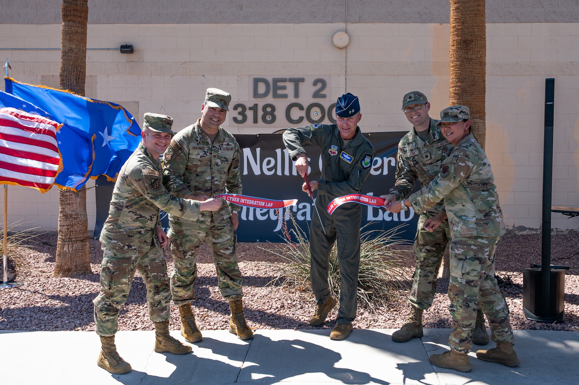 Service members cutting the ribbon at a ceremony.