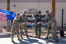 Service members cutting the ribbon at a ceremony.