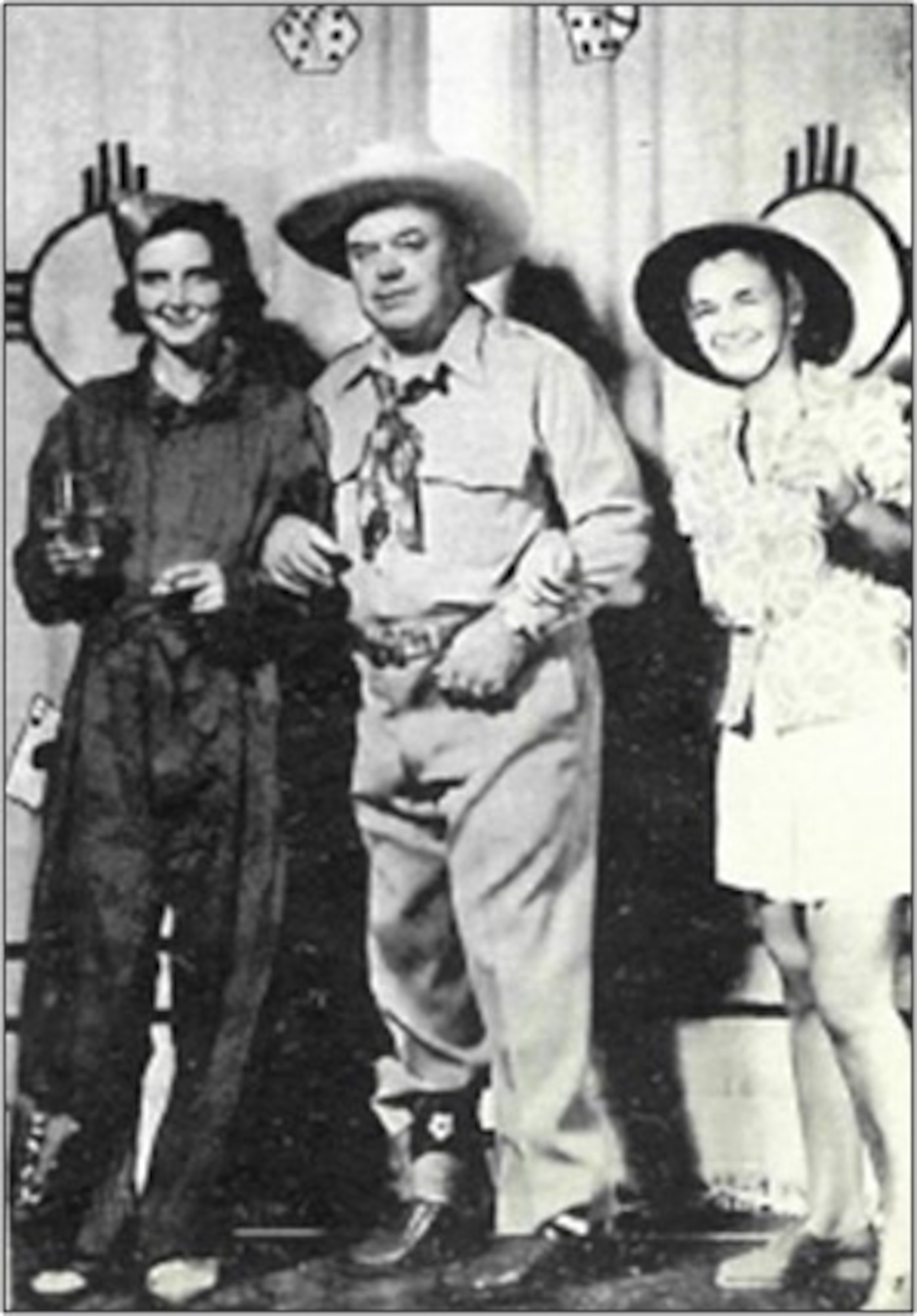 Man poses with two women for a photo at a morale event