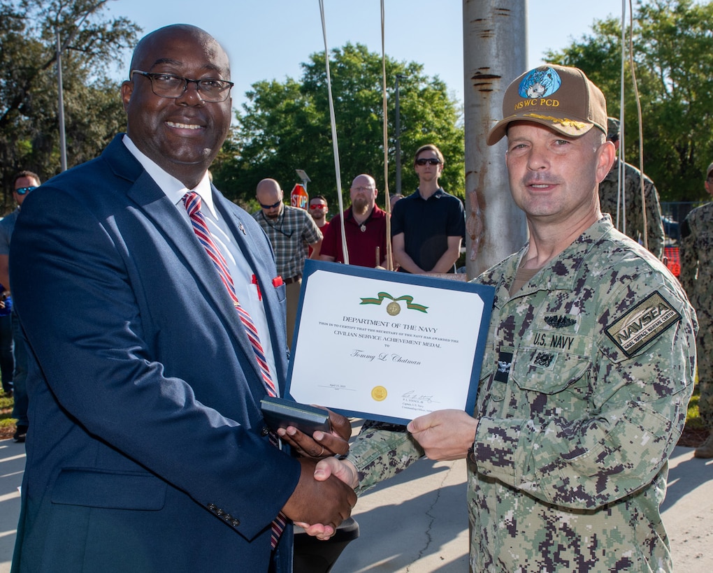 (right) Naval Surface Warfare Center Panama City Division Commanding Officer Capt. Paul Stence, Jr., awards Tommy Chatman with the Department of the Navy Civilian Service Achievement Medal, April 18. Chatman was a key contributor in acquiring the Standoff Reacquire Identify Detection Expeditionary Navigation Tool (STRIDENT) production contract for NSWC PCD. STRIDENT is a cutting-edge, long-range reconnaissance and targeting system that enhances the Navy's ability to identify and neutralize threats from a safe distance. (U.S. Navy photo by Anthony Powers)
