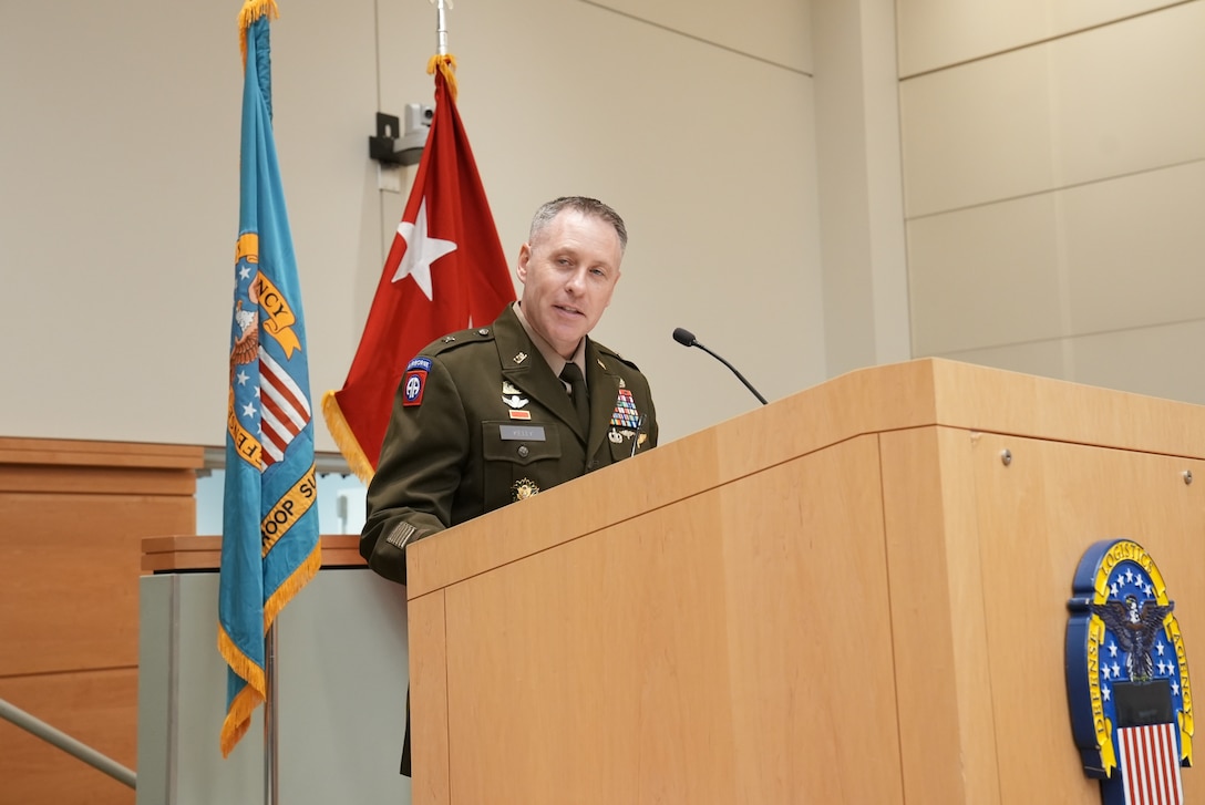 man in dress uniform stands at podium