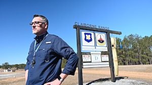 A civilian stands in front of the Claiborne Range entrance.