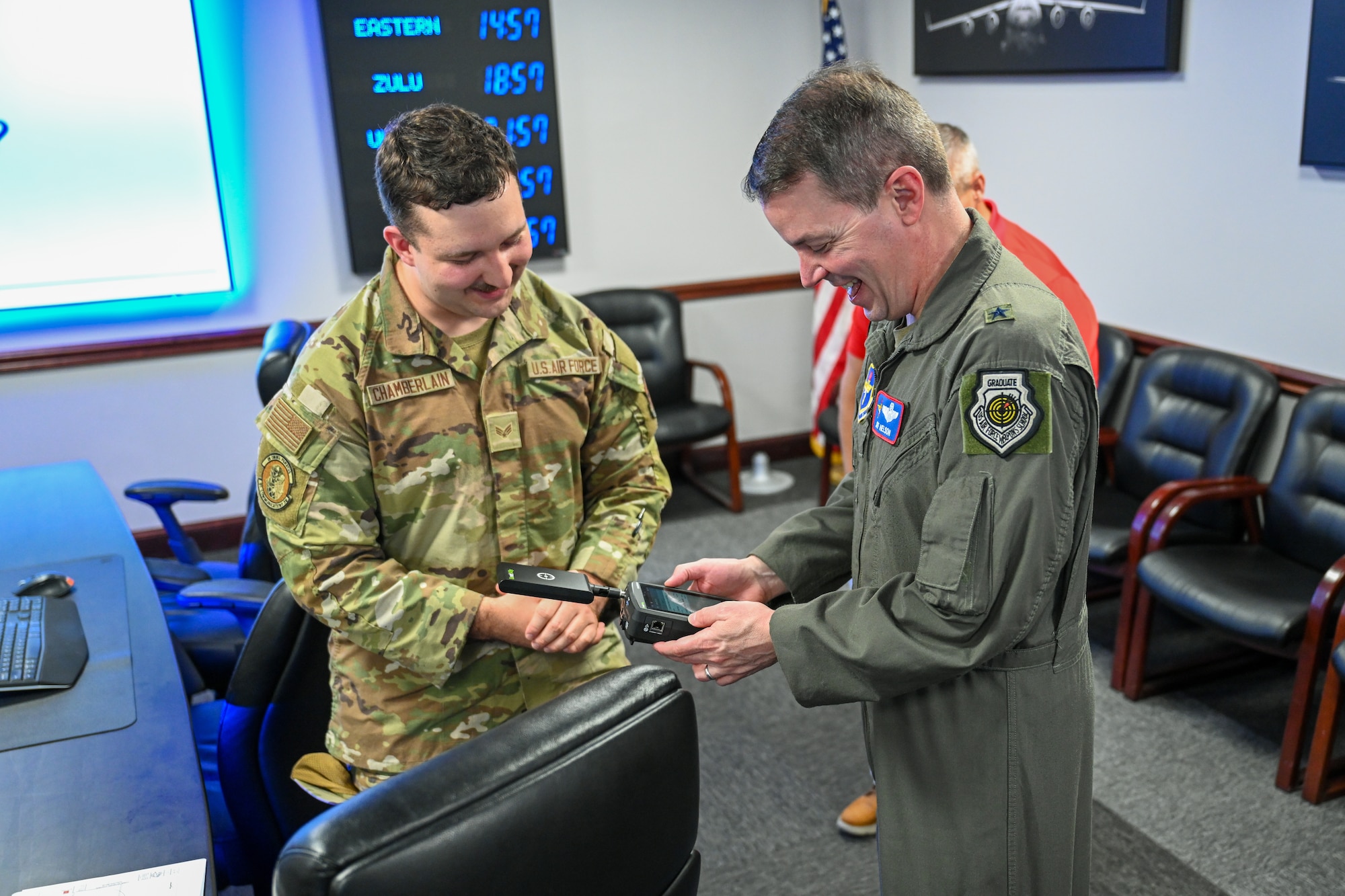 U.S. Air Force Brig. Gen. Jeffery Nelson, director of operations and communications for Air Education and Training Command, is taught the functions of a wireless frequency tracing device by Senior Airman Christopher Chamberlain, 97th Communications Squadron (CS) cybersecurity journeyman, at Altus Air Force Base, Oklahoma, June 9, 2025. Nelson was visiting the 97th CS to learn more about the day-to-day operations of cyber Airmen. (U.S. Air Force photo by Airman 1st Class Nathan Langston)