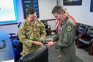 U.S. Air Force Brig. Gen. Jeffery Nelson, director of operations and communications for Air Education and Training Command, is taught the functions of a wireless frequency tracing device by Senior Airman Christopher Chamberlain, 97th Communications Squadron (CS) cybersecurity journeyman, at Altus Air Force Base, Oklahoma, June 9, 2025. Nelson was visiting the 97th CS to learn more about the day-to-day operations of cyber Airmen. (U.S. Air Force photo by Airman 1st Class Nathan Langston)