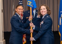 Photo of an Air Force member passing a squadron guidon to another Air Force member