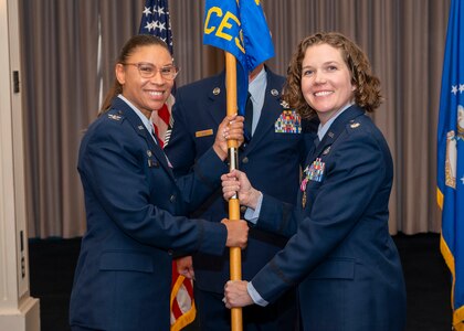Photo of an Air Force member passing a squadron guidon to another Air Force member