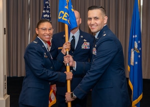 Photo of an Air Force member passing a squadron guidon to another Air Force member