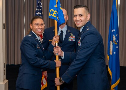 Photo of an Air Force member passing a squadron guidon to another Air Force member