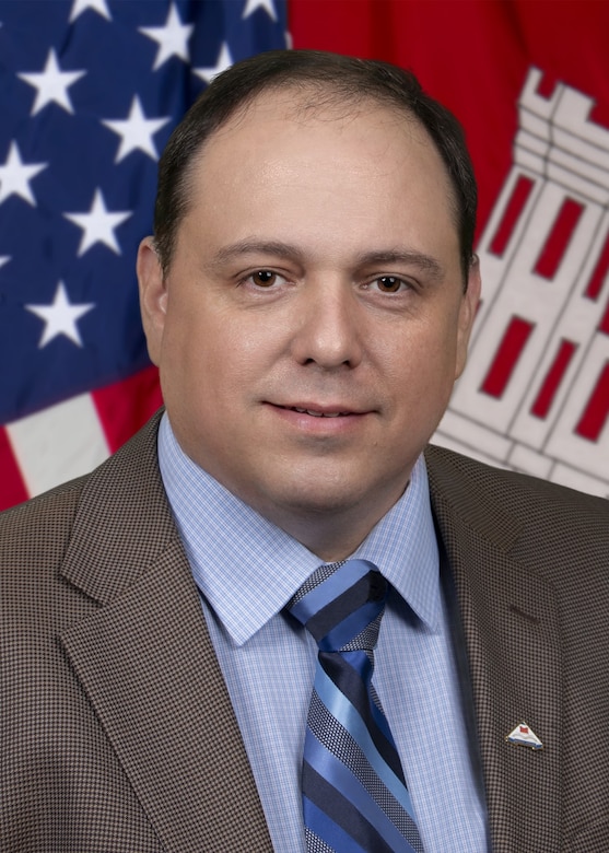 A headshot-style photo of a businessman with a tie and jacket.