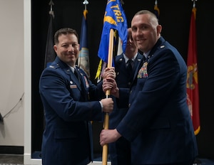 U.S. Air Force Col. Jason Gerber, 17th Training Group commander, passes the guidon to Lt. Col. Christopher Cardinale, incoming 313th Training Squadron commander, during the change of command ceremony at the Powell Event Center, Goodfellow Air Force Base, Texas, June 18, 2025. Before joining the 313th TRS, Cardinale was a strategy mission manager for the Office of the Director of National Intelligence. (U.S. Air Force photo by Senior Airman Evelyn J. D’Errico)
