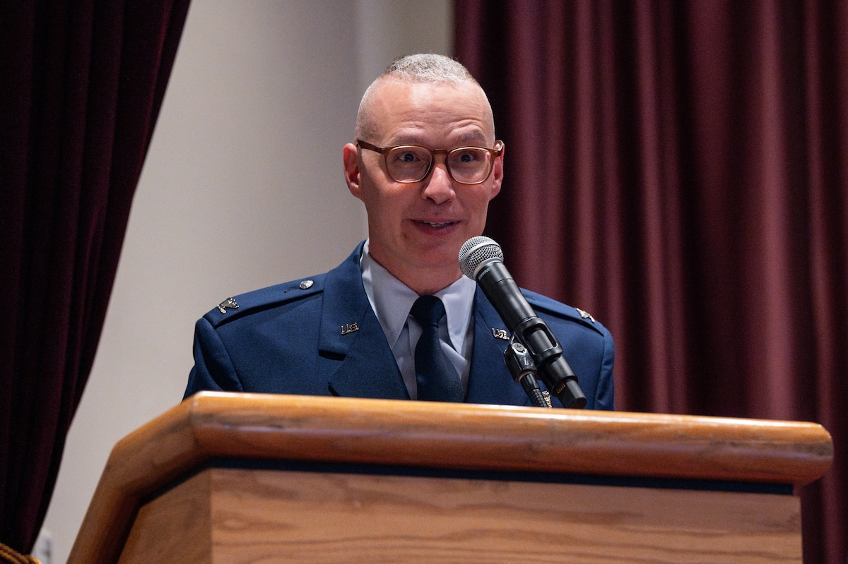 An airman behind a podium giving a speech