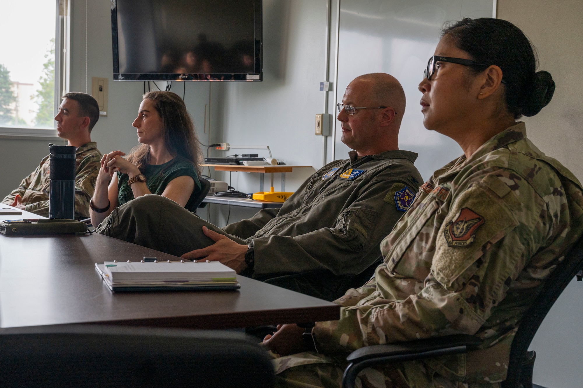Leaders from the 374th Airlift Wing sit at a table and listen to questions and concerns during a spouse coffee chat.