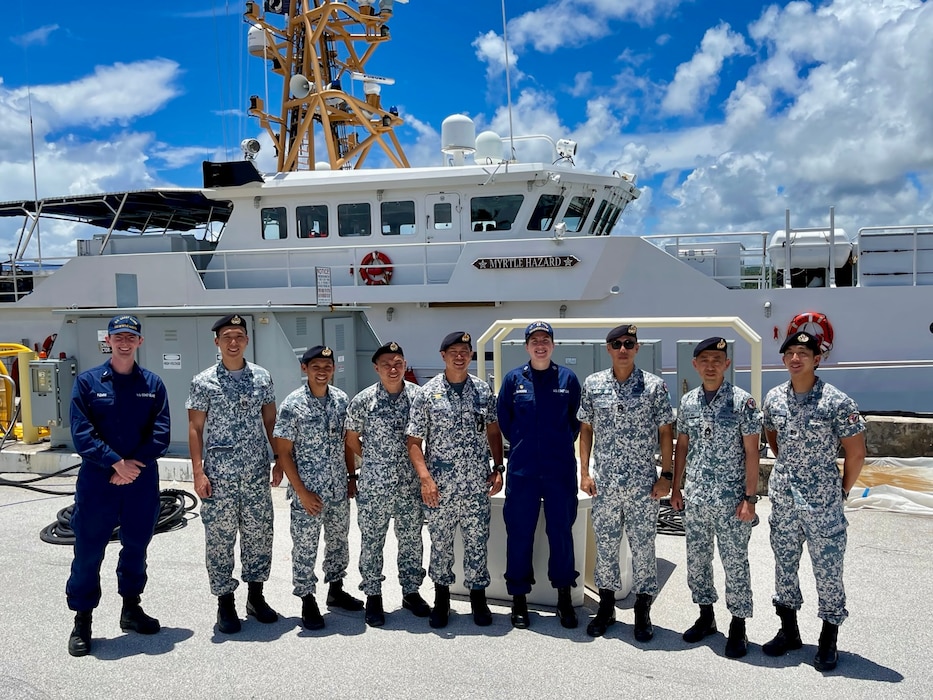 Lt. Emma Saunders, commanding officer of USCGC Myrtle Hazard (WPC 1139) and members of the Republic of Singapore Naval Diving Unit stand for a photo in Guam on June 11, 2025.