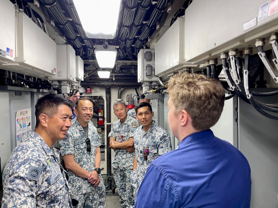 Lt. Emma Saunders, commanding officer, gives a tour of her ship, the USCGC Myrtle Hazard (WPC 1139), to members of the Republic of Singapore Naval Diving Unit in Guam on June 11, 2025.