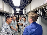 Lt. Emma Saunders, commanding officer, gives a tour of her ship, the USCGC Myrtle Hazard (WPC 1139), to members of the Republic of Singapore Naval Diving Unit in Guam on June 11, 2025.