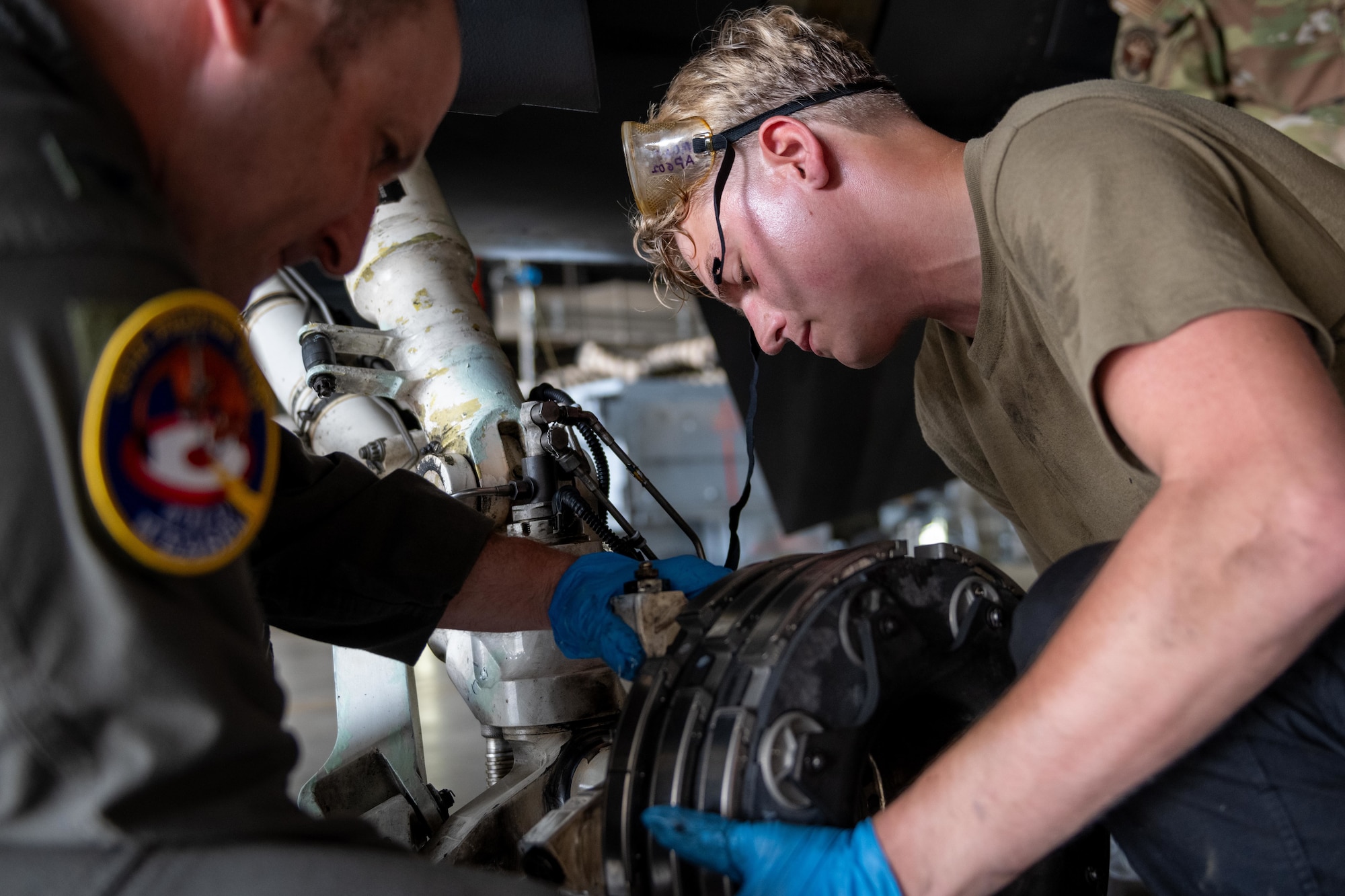 U.S. Air Force Senior Airman Derek Johnson, right, 14th Fighter Generation Squadron F-16 Fighting Falcon assistant dedicated crew chief, inserts a new F-16 brake pad with the help of U.S. Air Force Col. Matthew Kenkel, 35th Fighter Wing deputy commander, during a Wild Weasel Walkthrough.