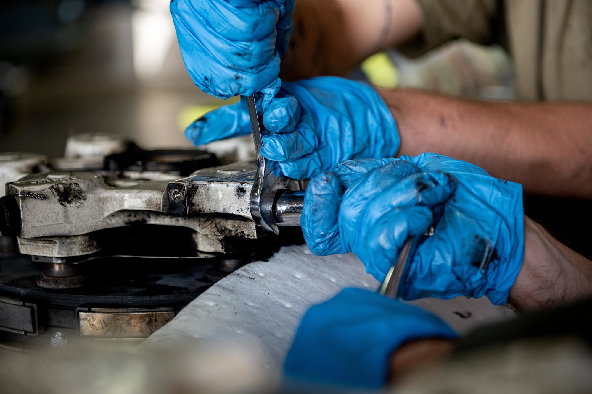 U.S. Air Force Col. Matthew Kenkel, right, 35th Fighter Wing deputy commander, and U.S. Air Force Senior Airman Derek Johnson, 14th Fighter Generation Squadron F-16 Fighting Falcon assistant dedicated crew chief, removes a bolt from a used brake pad.