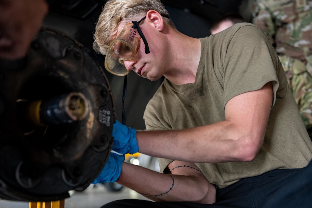 U.S. Air Force Senior Airman Derek Johnson, 14th Fighter Generation Squadron F-16 Fighting Falcon assistant dedicated crew chief, loosens a bolt to remove a used F-16 brake pad.