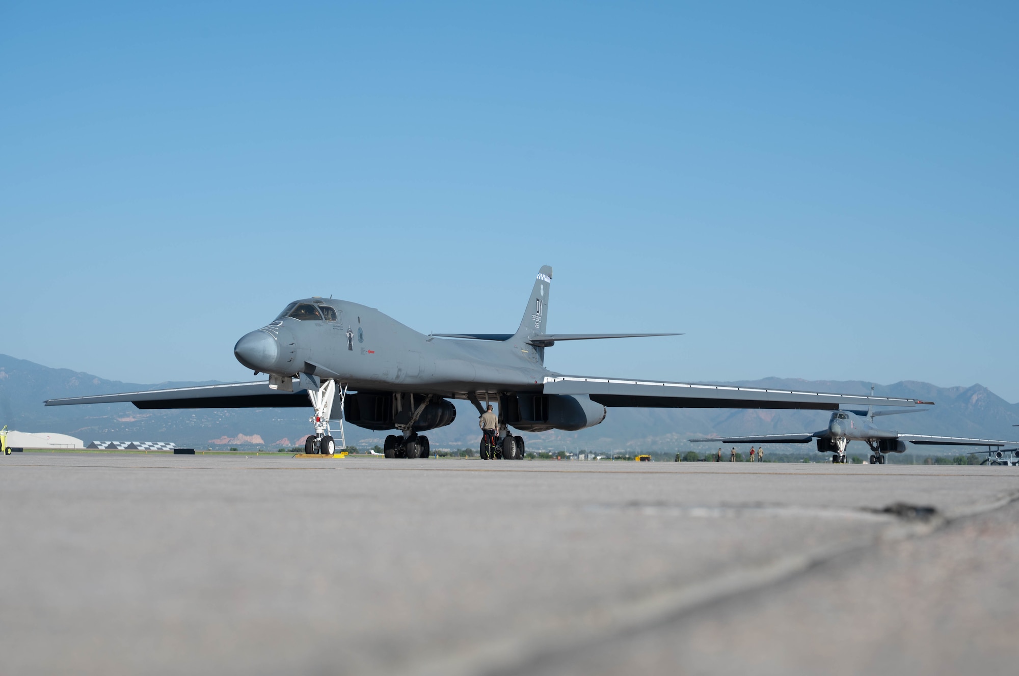 Two B-1B Lancer aircraft sit on the Peterson SFB flightline